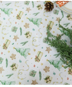 Detail of Christmas tablecloth showing watercolor pine trees and gifts on white fabric