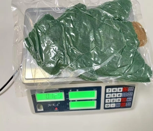 Detail of a green Christmas tree shaped pillow in protective clear plastic packaging