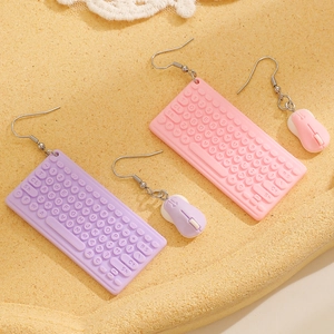Detail of creative resin keyboard and mouse earrings in pastel pink and purple tones