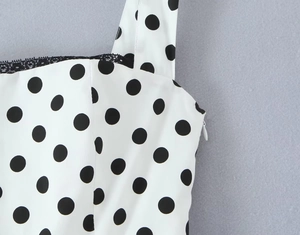 Détail du tissu à pois blancs avec dentelle noire et fermeture éclair latérale invisible