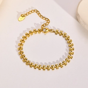 Detail of 18K gold heart-shaped link bracelet featuring lobster clasp and extension chain