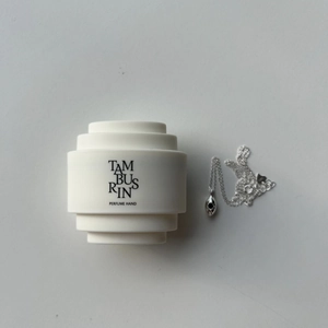 Detail of S925 sterling silver waterdrop necklace beside a Tamburins perfume hand cream