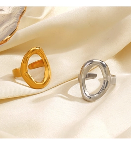Detailed close-up of gold and silver irregular oval open rings on soft white satin fabric