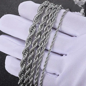Polished silver stainless steel rope chains in various sizes held in hand closeup view