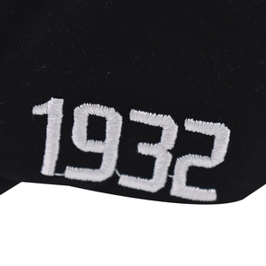 Macro shot of 1932 embroidery on black washed cotton baseball cap with fine texture