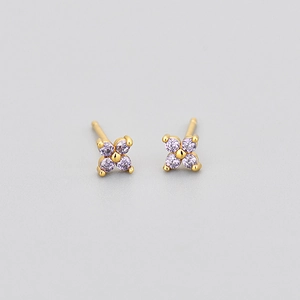 Macro shot of gold four-leaf flower earrings with lavender round-cut zircon stones