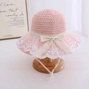 Detail of pink straw sun hat for girls with lace trim, bow and adjustable chin strap