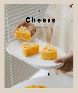 Close-up of yellow cheese-shaped scented candles on a tray with natural lighting