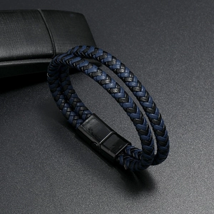 Dettaglio del bracciale in pelle intrecciata a doppio strato nero e blu con chiusura magnetica