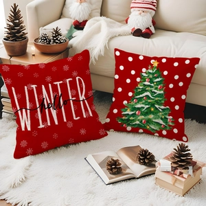 Close-up of red Christmas pillow covers with Winter lettering and tree on white fur rug