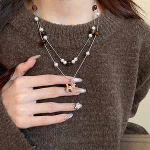 Collier double rang en œil de tigre et perles avec un pendentif cheval à bascule brillant