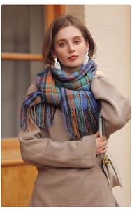 Detail of plaid winter scarf with colorful tassels and soft cashmere-like texture