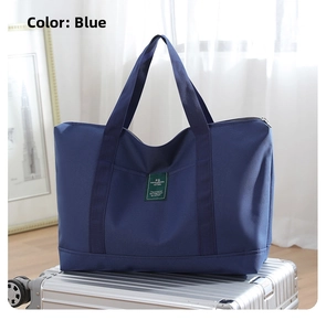 Large blue canvas travel bag shown on top of a silver suitcase for travel scene