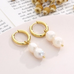 Vue macro détaillée des boucles d'oreilles en or 18 carats avec deux perles blanches