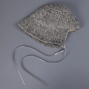 Close-up of handwoven summer sun hat showing gray braided texture and satin ribbons