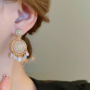 Detail of dreamcatcher earrings featuring pink beads and iridescent teardrop pendants