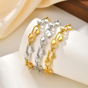 Golden and silver stainless steel link bracelets with heart charms on white display
