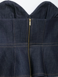 Detailed close-up of dark blue denim corset top featuring a front metallic zipper and stitching