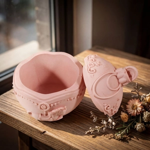 Detail of pink resin storage box featuring embossed carousel pattern on wooden desk