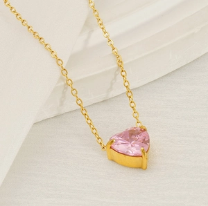 Close-up of gold-plated heart necklace with sparkling pink heart-shaped zircon gemstone
