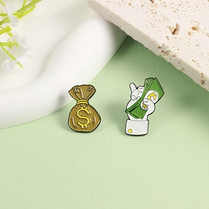 Cartoon money bag and cash enamel pins with gold dollar signs on green background