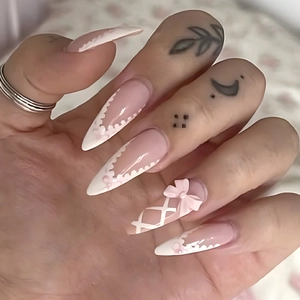 Pink and white French stiletto press-on nails with 3D bows and lace patterns
