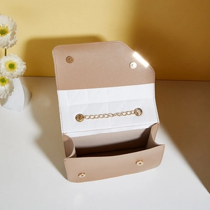 Minimalist beige crossbody bag with gold chain strap and magnetic snap closure