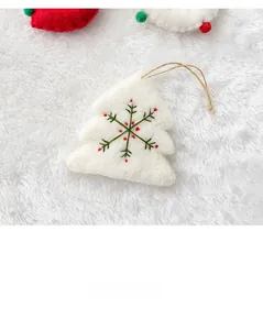 Detailed macro view of wool felt Christmas tree ornament with green and red embroidery