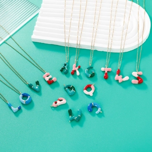 Colorful enamel alphabet letter pendants on gold chains over turquoise background