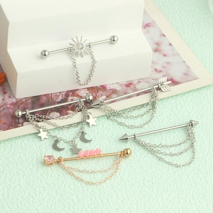 Industrial barbell earrings featuring sun and moon pendants with delicate metal chains