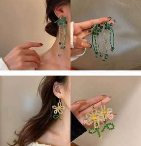 Detailed view of handmade beaded tassel earrings with green daisies and floral accents