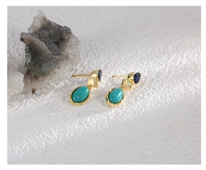 Detailed close-up of gold drop earrings with blue zircon and turquoise stones