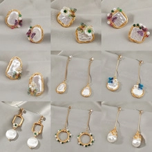 Baroque retro earring set featuring pearls floral designs and tassels on grey fabric