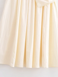 Close-up of cream white lace hem and textured cotton fabric on this stylish midi skirt