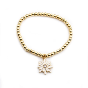 Gros plan du bracelet en perles dorées avec pendentif marguerite blanche et cristal