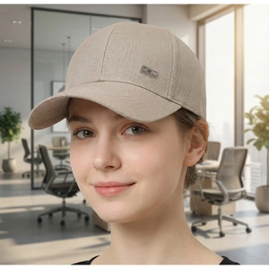 Detailed close-up of beige twill baseball cap featuring a decorative metal logo plate