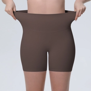 Détail du short de yoga taille haute marron foncé montrant l'élasticité et le gainage du ventre
