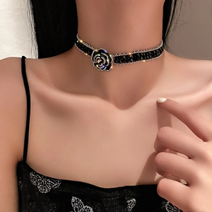 Detail of black camellia choker featuring crystal-encrusted edges and beaded necklace chain