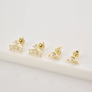Detail view of S925 silver stud earrings with opal stone and delicate pearl in gold