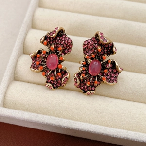 Vue macro des boucles d'oreilles vintage avec cristaux roses et perles orange en boîte velours
