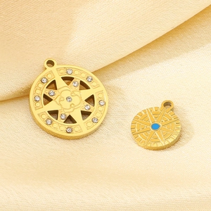 Detail of golden starburst pendants with clear rhinestones and blue gemstones on silk cloth