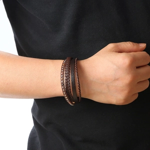Close-up of men's dark brown multilayered braided leather bracelet with metal rivets