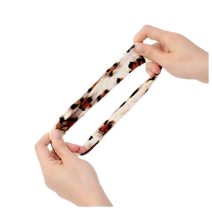 Elastic leopard print scrunchie hair tie being stretched by hands to show its high elasticity