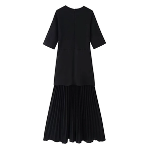 Detail of elegant black short sleeve dress featuring a delicate pleated chiffon hem design