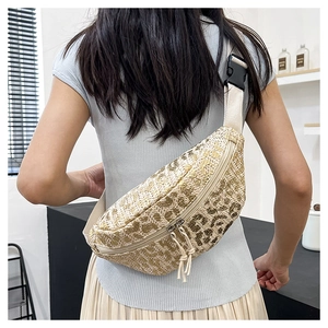 Detail of straw waist bag with leopard texture and adjustable strap worn by model