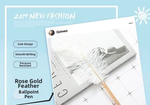 Close-up of rose gold feather ballpoint pen on a magazine with an elegant design