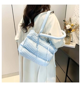 Gros plan d'un sac cabas matelassé à rayures bleues et blanches avec nœud décoratif