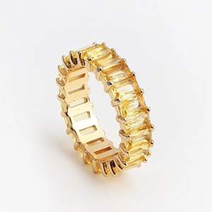 Vue détaillée d'une bague dorée ornée de zircons jaunes en taille émeraude sur tout le tour