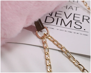 Detail of pink plush faux fur bag showing golden metal chain connection and D-ring buckle
