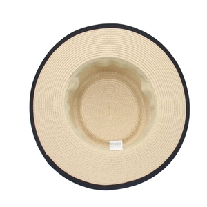 Dettaglio interno del cappello di paglia con etichetta 100% carta e nastro nero decorativo